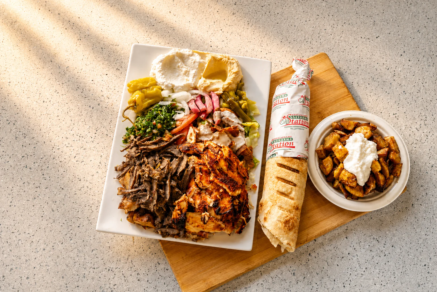 Shawarma Station mixed shawarma platter with a wrapped shawarma and garlic potatoes